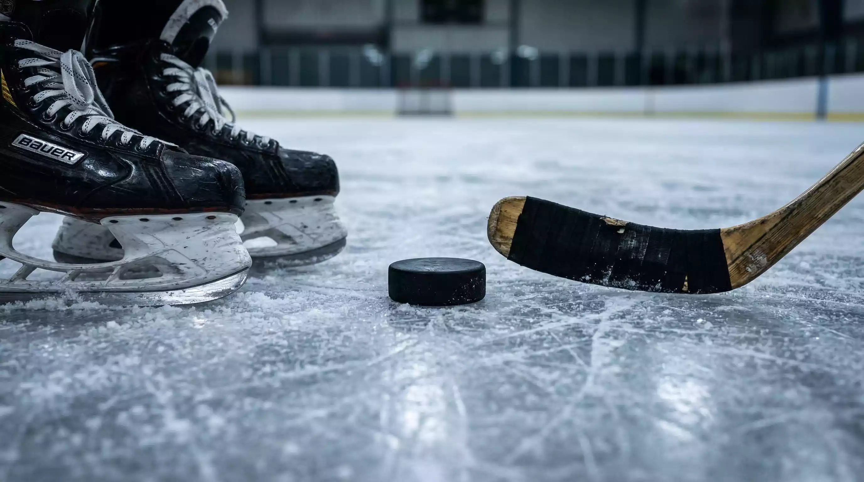 Equipamiento de hockey sobre hielo dispuesto sobre una superficie de hielo: stick, puck y patines