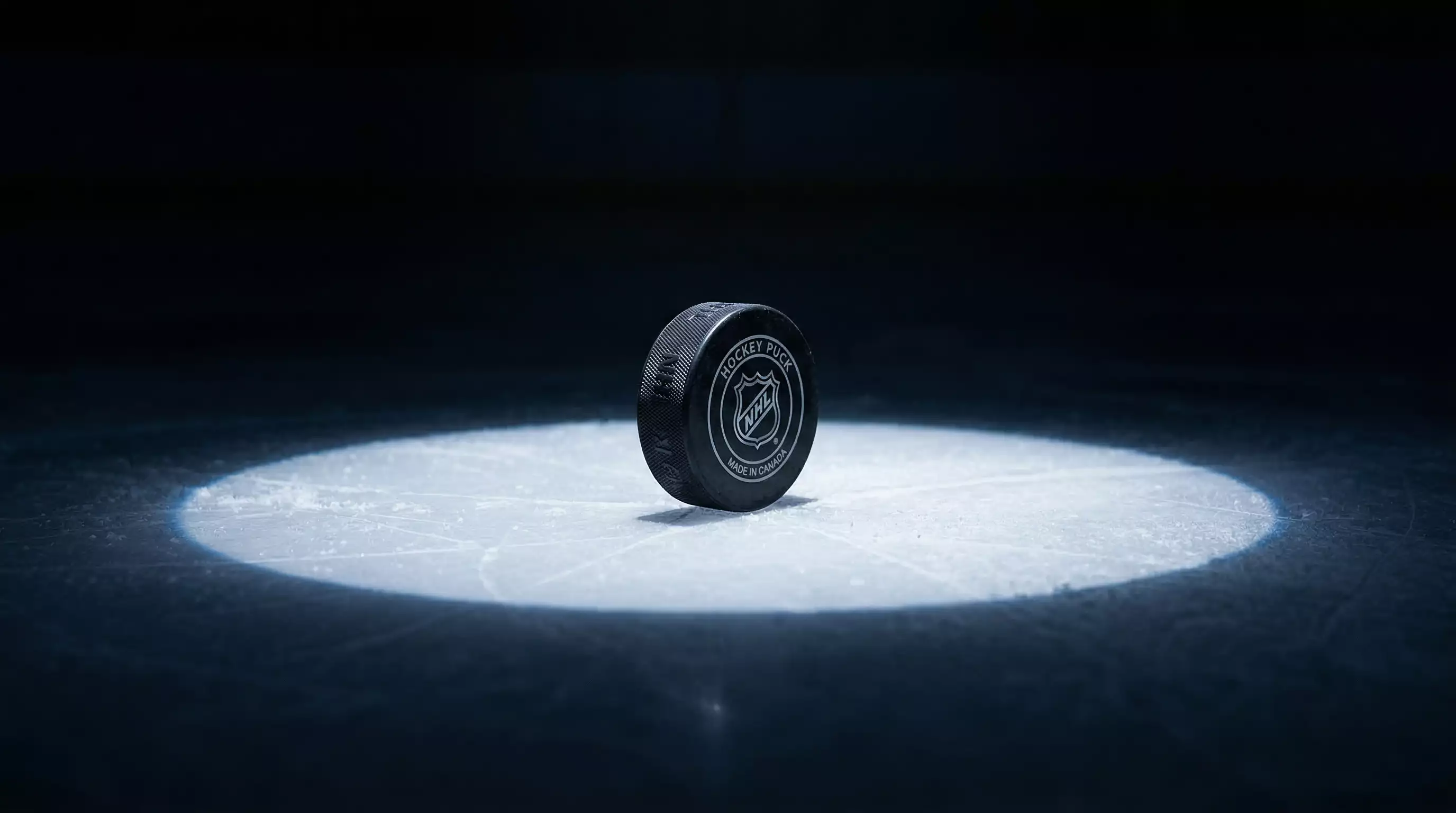 Disco de hockey sobre hielo bajo un foco cenital representando análisis estadístico